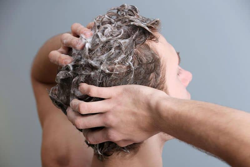 άντρας λούζει τα μαλλιά του
