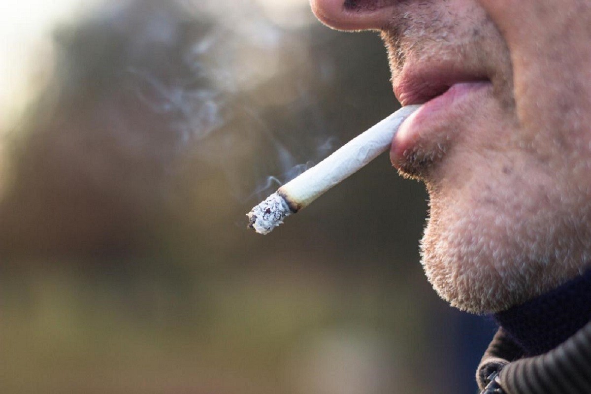άνδρας με τσιγάρο στο στόμα απολαμβάνει το κάπνισμα