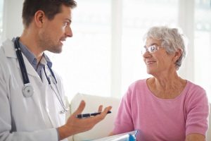 ηλικιωμένη γυναίκα ασθενής μιλά με τον γιατρό της