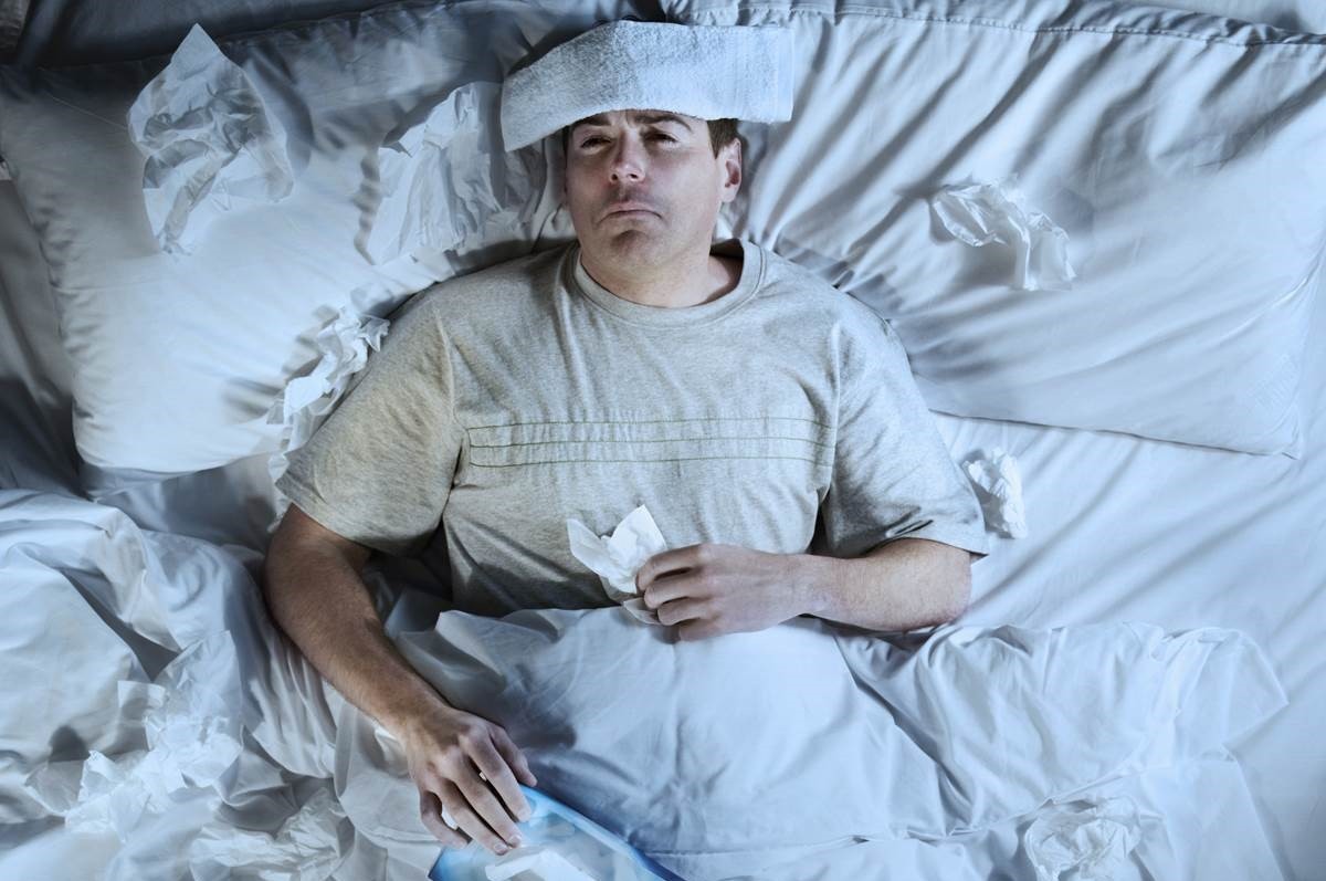 άνδρας άρρωστος στο κρεβάτι με πυρετό
