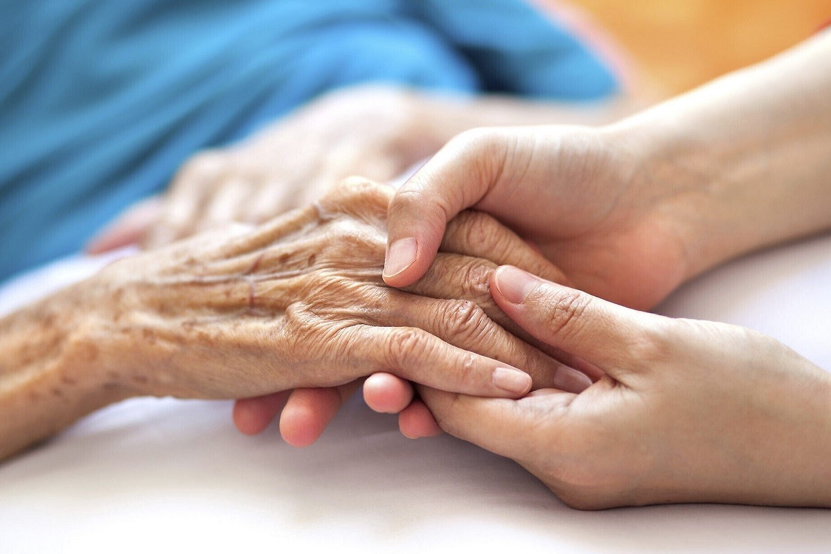 κοπέλα κρατά το χέρι ηλικιωμένης με Αλτσχάιμερ
