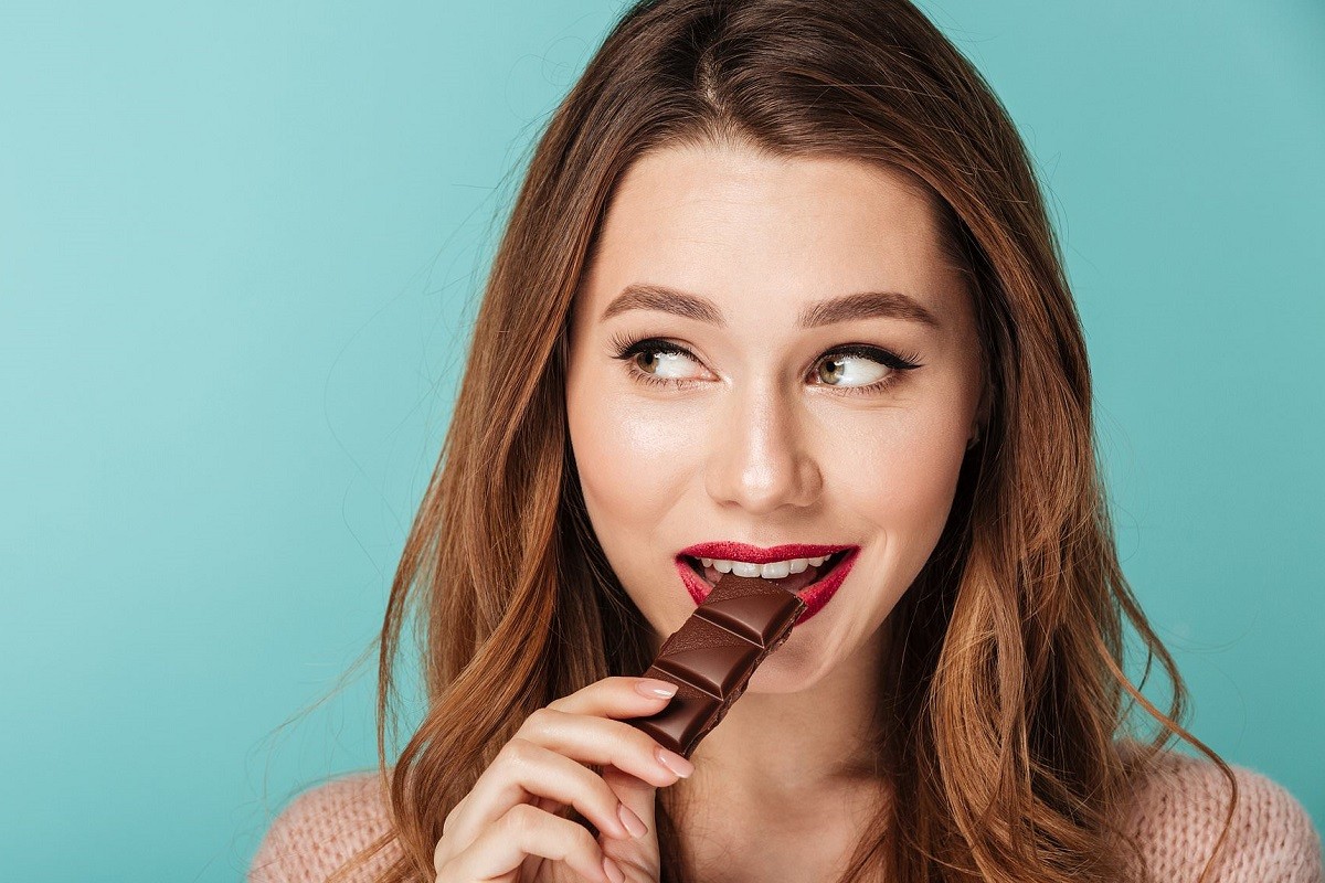 νεαρή γυναίκα τρώει σοκολάτα