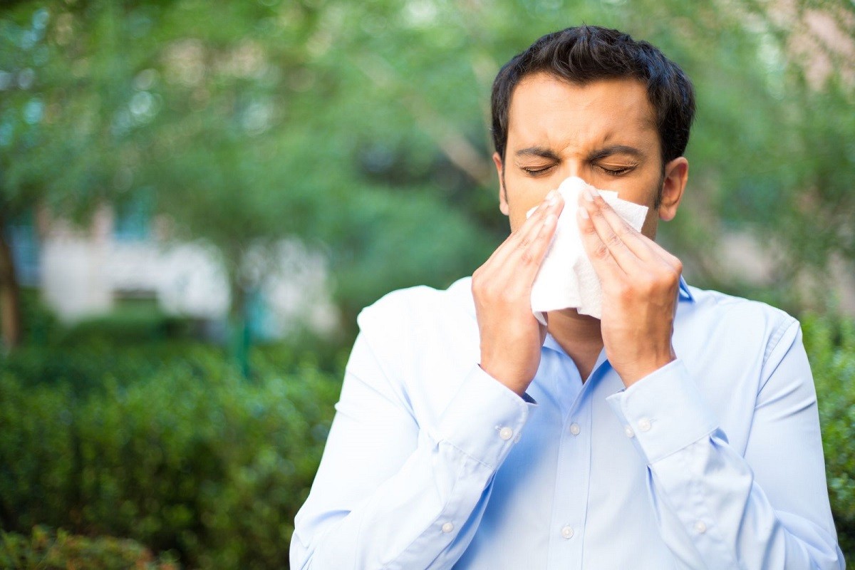 άνδρας με αλλεργίες φυσάει τη μύτη του