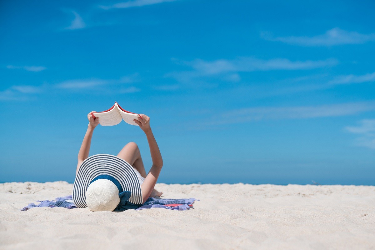 γυναίκα που κάνει διακοπές είναι ξαπλωμένη στην παραλία