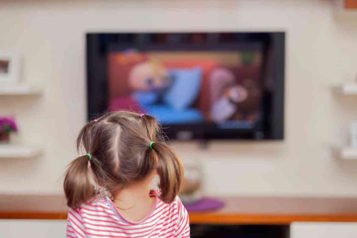 ένα παιδί, μικρό κοριτσάκι, βλέπει τηλεόραση