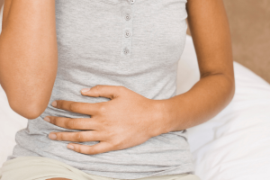γυναίκα που κρατά την κοιλιάν της επειδή πονάει εξαιτίας της νόσου του Crohn