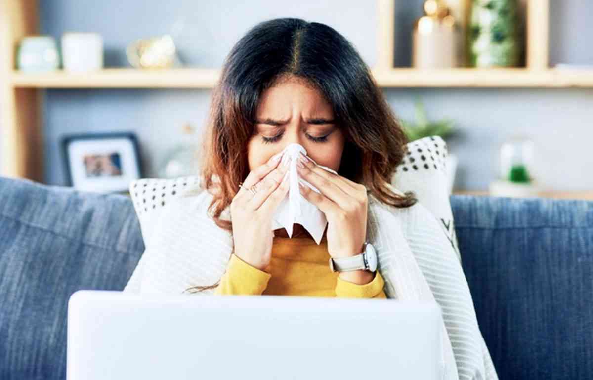 γυναίκα με γρίπη φυσάει τη μύτη της για να φύγουν οι ιώσεις