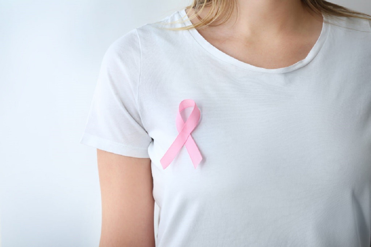 γυναίκα φοράει ροζ κορδέλα για τις γυναίκες που τις έχει χτυπήσει ο καρκίνος του μαστού