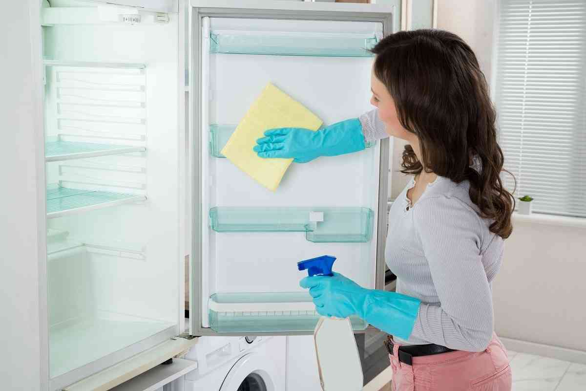 γυναίκα καθαρίζει το ψυγείο στην κουζίνα