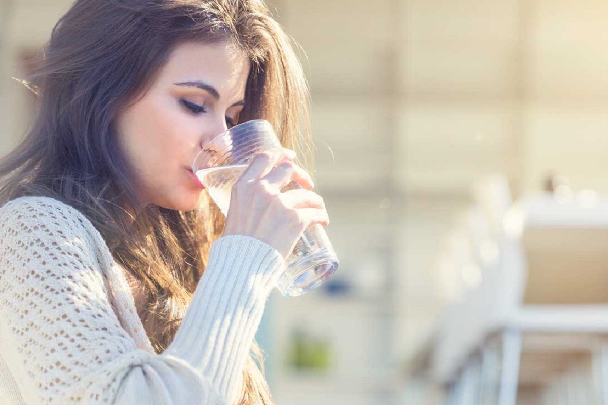 νεαρή γυναίκα πίνει νερό