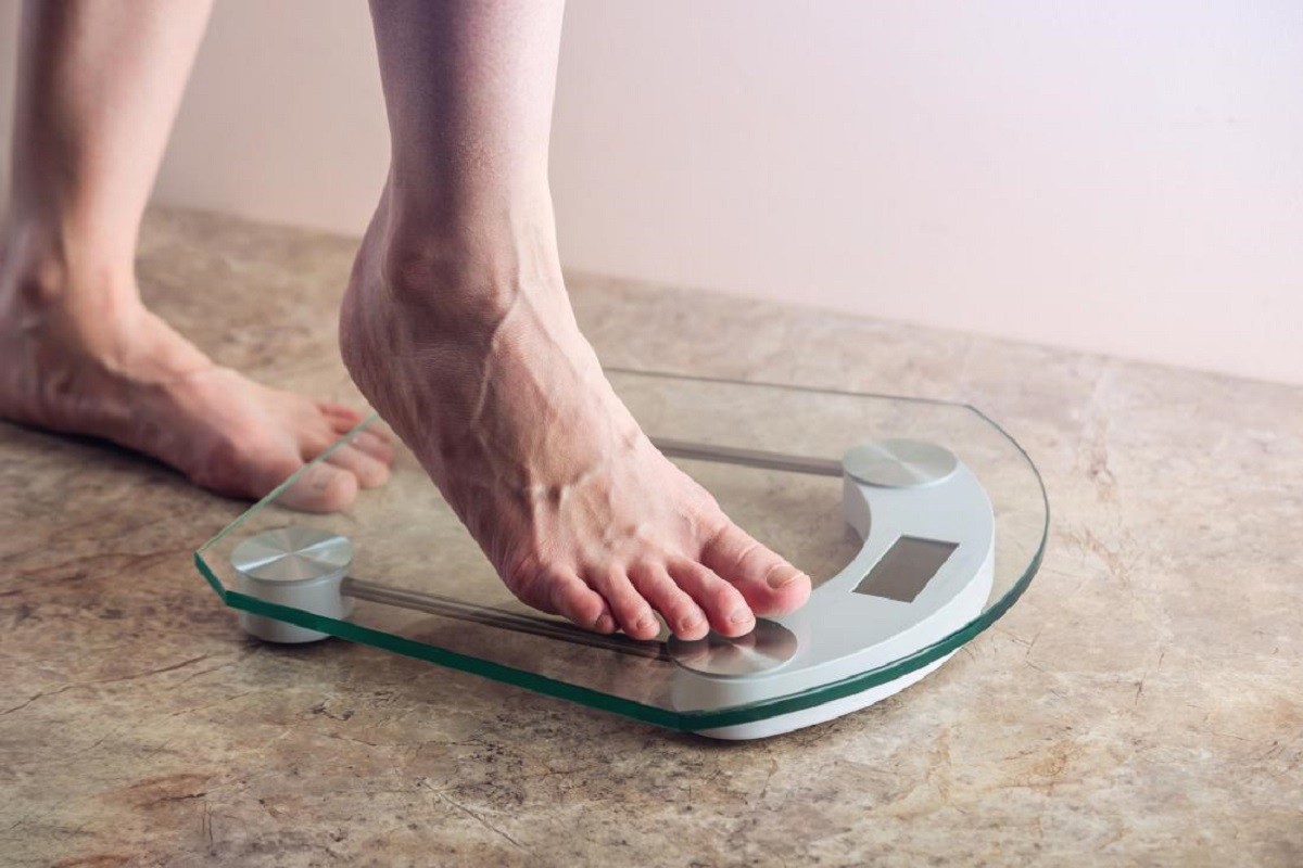 γυναίκα ανεβαίνει σε ζυγαριά για να δει αν έχει πάρει βάρος