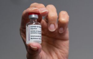 άνδρας κρατά εμβόλιο για να καταπολεμηθεί ο κορωνοϊός