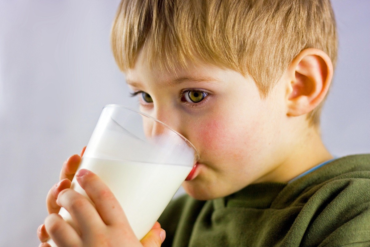 παιδί πίνει ένα ποτήρι γάλα