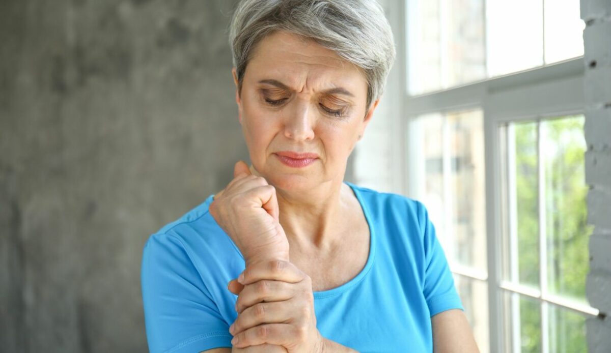 γυναίκα που πιάνει το χέρι της επειδή πονάει από την οστοπόρωση