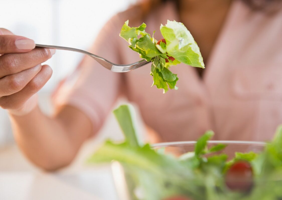 γυναίκα τρώει σαλάτα γιατί ακολουθεί την χορτοφαγία