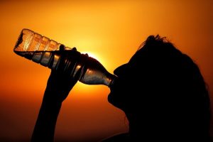 γυναίκα πίνει νερό για να αντιμετωπιστεί ο καύσωνας