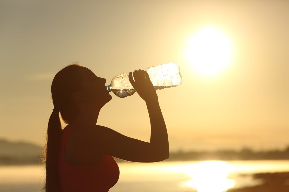 γυναίκα πίνει νερό για να αντιμετωπίσει την ζέστη